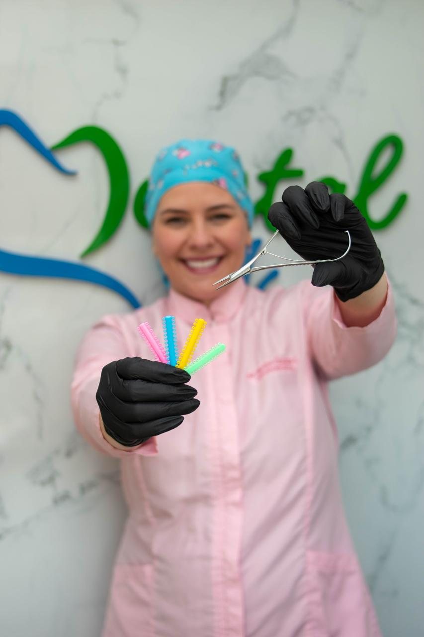 Od. Marilyn Chejade L. mostrando ligas de colores para brackets
